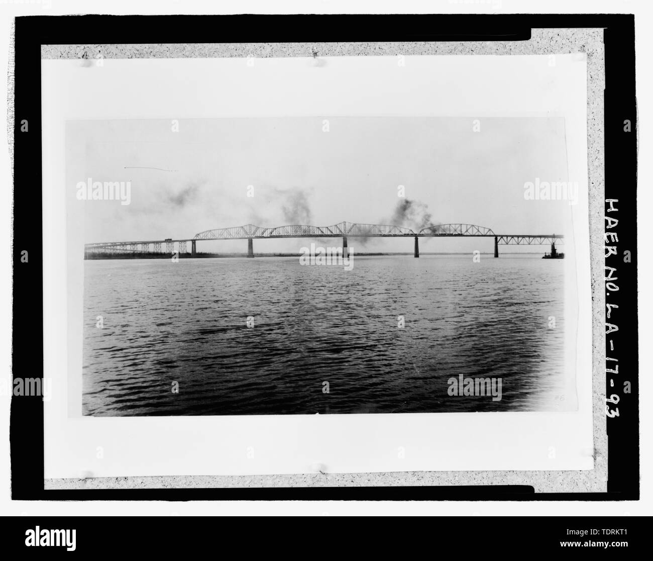 Copia fotografica di inizio 20E-148; x 33E-148;, la fotografia in bianco e nero. Trova allentato nella casella di grandi dimensioni presso il Museo Nazionale della Storia Americana, Smithsonian Institution, archivi Center, il lavoro e la Divisione Industria, Washington D.C. Fotografo originale sconosciuto.; prime fotografie di ponte preso dal fiume VICINO ORIENTE BANK GUARDANDO VERSO SUD-OVEST FINO FIUME VERSO WEST BANK mostra locomotiva a vapore treno attraversando Ponte. - Huey P. lungo ponte, spanning del fiume Mississippi a circa metà strada tra nove e dodici punti miglia a monte ed a ovest di New Orleans, Jefferson, Jefferson Par Foto Stock