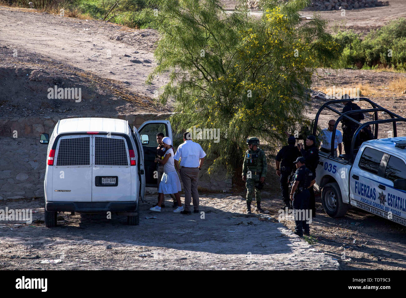 Giugno 18, 2019 - Personale dal Messico di Instituto Nacional de Migraci ""n, Messico della agenzia di immigrazione, caricare due migranti nei furgoni che sono stati arrestati da personale militare dal EjÅ½rcito Mexicano, Messico army, lungo il Rio Grande in Ciudad Ju''¡rez, Chihuahua, MÅ½xico. I migranti sono stati sospettati di tentare di attraversare illegalmente il Rio Grande negli Stati Uniti attraverso El Paso, Texas. Secondo il messicano del personale militare, iniziarono il pattugliamento del confine in Ciudad Ju''¡rez il 16 giugno con intenzioni per prevenire l'immigrazione illegale negli Stati Uniti. (Credito Immagine: © Joe Foto Stock