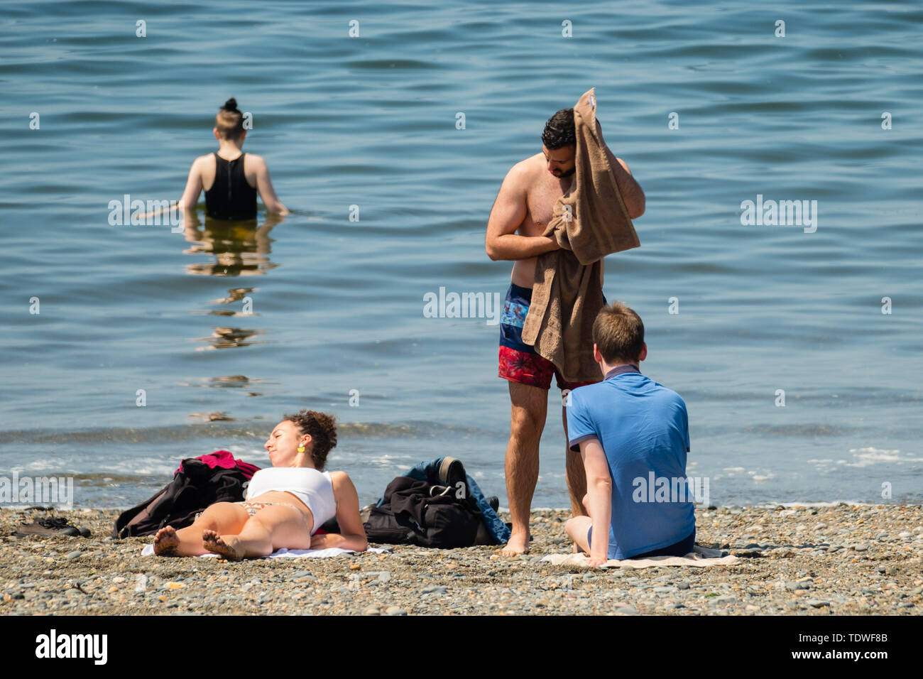 Aberystwyth Wales UK, mercoledì 19 giugno 2019 UK Meteo:dopo giorni di unseasonal heavy rain e grigio cielo nuvoloso, il sole fa un aspetto di benvenuto, e richiama gente torna alla spiaggia e al lungomare di Aberystwyth su Cardigan Bay costa, West Wales Photo credit: keith morris/Alamy Live News Credito: keith morris/Alamy Live News Foto Stock