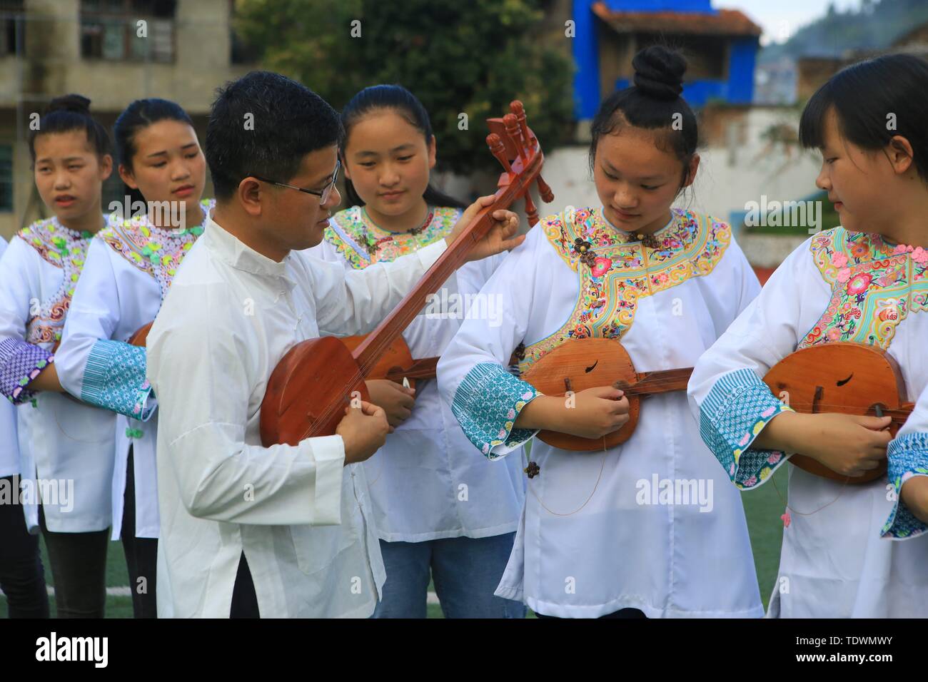 Qiandongnan, della Cina di Guizhou. 19 giugno 2019. Un insegnante guida gli studenti a pipa (4 corde liuto cinese) cantando la Dong gruppo etnico a Leli Middle School di Rongjiang contea di Qiandongnan Miao e Dong prefettura autonoma, a sud-ovest della Cina di Guizhou, 19 giugno 2019. Nel corso degli anni, varie attività dei gruppi etnici sono stati lanciati in Rongjiang County, in modo che gli studenti possano imparare in un ambiente con colture diversificate e di ereditare le culture etniche. Credito: Yang Wenshu/Xinhua/Alamy Live News Foto Stock