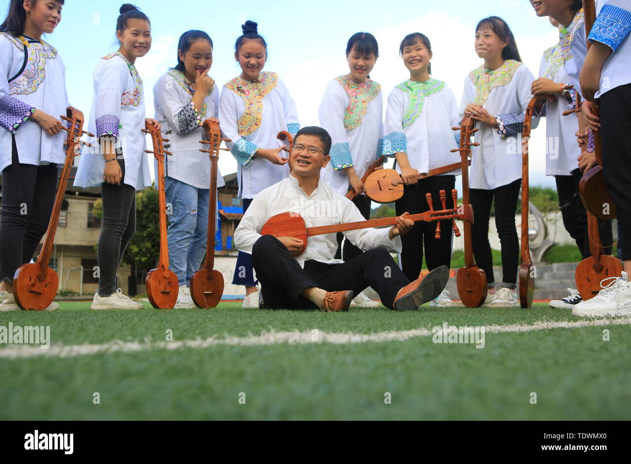 Qiandongnan, della Cina di Guizhou. 19 giugno 2019. Un insegnante guida gli studenti a pipa (4 corde liuto cinese) cantando la Dong gruppo etnico a Leli Middle School di Rongjiang contea di Qiandongnan Miao e Dong prefettura autonoma, a sud-ovest della Cina di Guizhou, 19 giugno 2019. Nel corso degli anni, varie attività dei gruppi etnici sono stati lanciati in Rongjiang County, in modo che gli studenti possano imparare in un ambiente con colture diversificate e di ereditare le culture etniche. Credito: Yang Wenshu/Xinhua/Alamy Live News Foto Stock