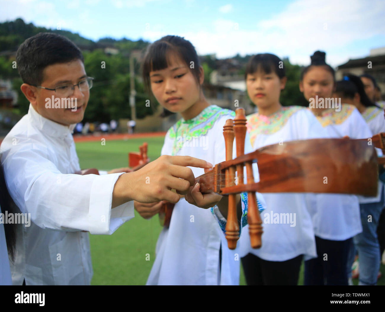 Qiandongnan, della Cina di Guizhou. 19 giugno 2019. Un insegnante guida gli studenti a pipa (4 corde liuto cinese) cantando la Dong gruppo etnico a Leli Middle School di Rongjiang contea di Qiandongnan Miao e Dong prefettura autonoma, a sud-ovest della Cina di Guizhou, 19 giugno 2019. Nel corso degli anni, varie attività dei gruppi etnici sono stati lanciati in Rongjiang County, in modo che gli studenti possano imparare in un ambiente con colture diversificate e di ereditare le culture etniche. Credito: Yang Wenshu/Xinhua/Alamy Live News Foto Stock