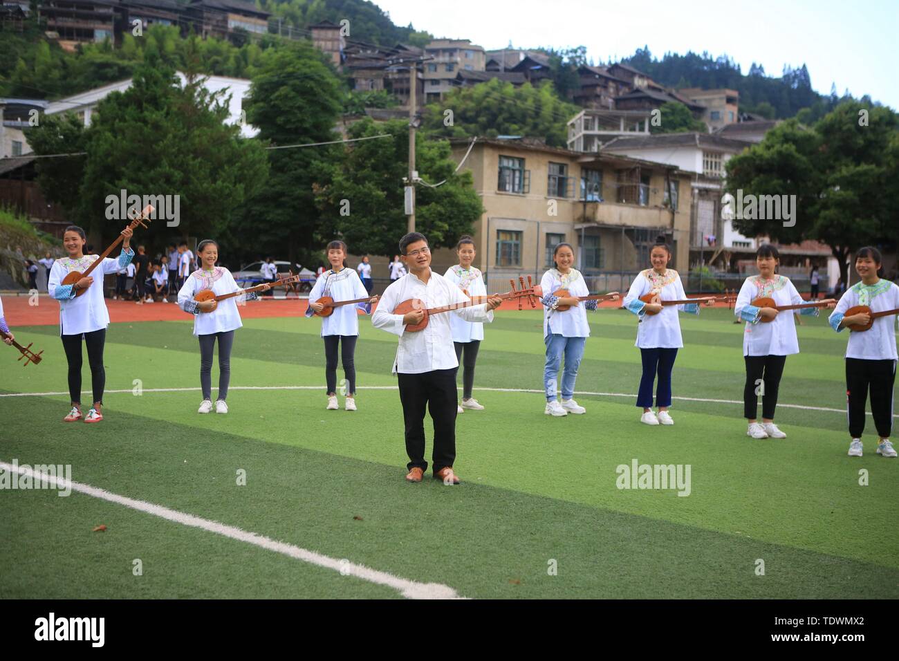 Qiandongnan, della Cina di Guizhou. 19 giugno 2019. Un insegnante e gli studenti svolgono pipa (4 corde liuto cinese) cantando la Dong gruppo etnico a Leli Middle School di Rongjiang contea di Qiandongnan Miao e Dong prefettura autonoma, a sud-ovest della Cina di Guizhou, 19 giugno 2019. Nel corso degli anni, varie attività dei gruppi etnici sono stati lanciati in Rongjiang County, in modo che gli studenti possano imparare in un ambiente con colture diversificate e di ereditare le culture etniche. Credito: Yang Wenshu/Xinhua/Alamy Live News Foto Stock
