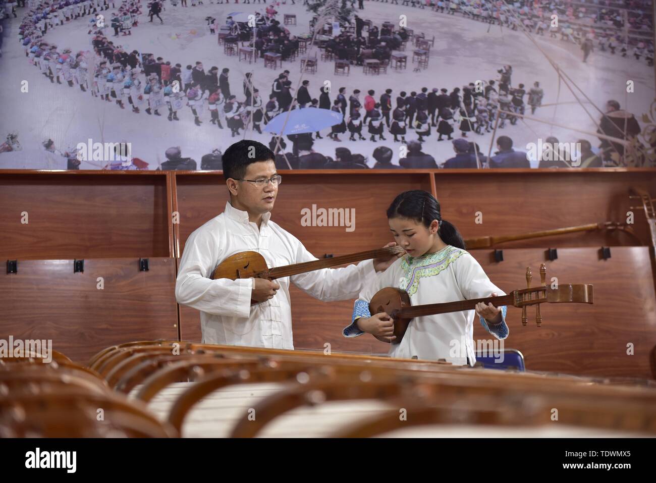 Qiandongnan, della Cina di Guizhou. 19 giugno 2019. Un insegnante guida uno studente in Pipa (4 corde liuto cinese) cantando la Dong gruppo etnico a Leli Middle School di Rongjiang contea di Qiandongnan Miao e Dong prefettura autonoma, a sud-ovest della Cina di Guizhou, 19 giugno 2019. Nel corso degli anni, varie attività dei gruppi etnici sono stati lanciati in Rongjiang County, in modo che gli studenti possano imparare in un ambiente con colture diversificate e di ereditare le culture etniche. Credito: Jiang Zuoxian/Xinhua/Alamy Live News Foto Stock
