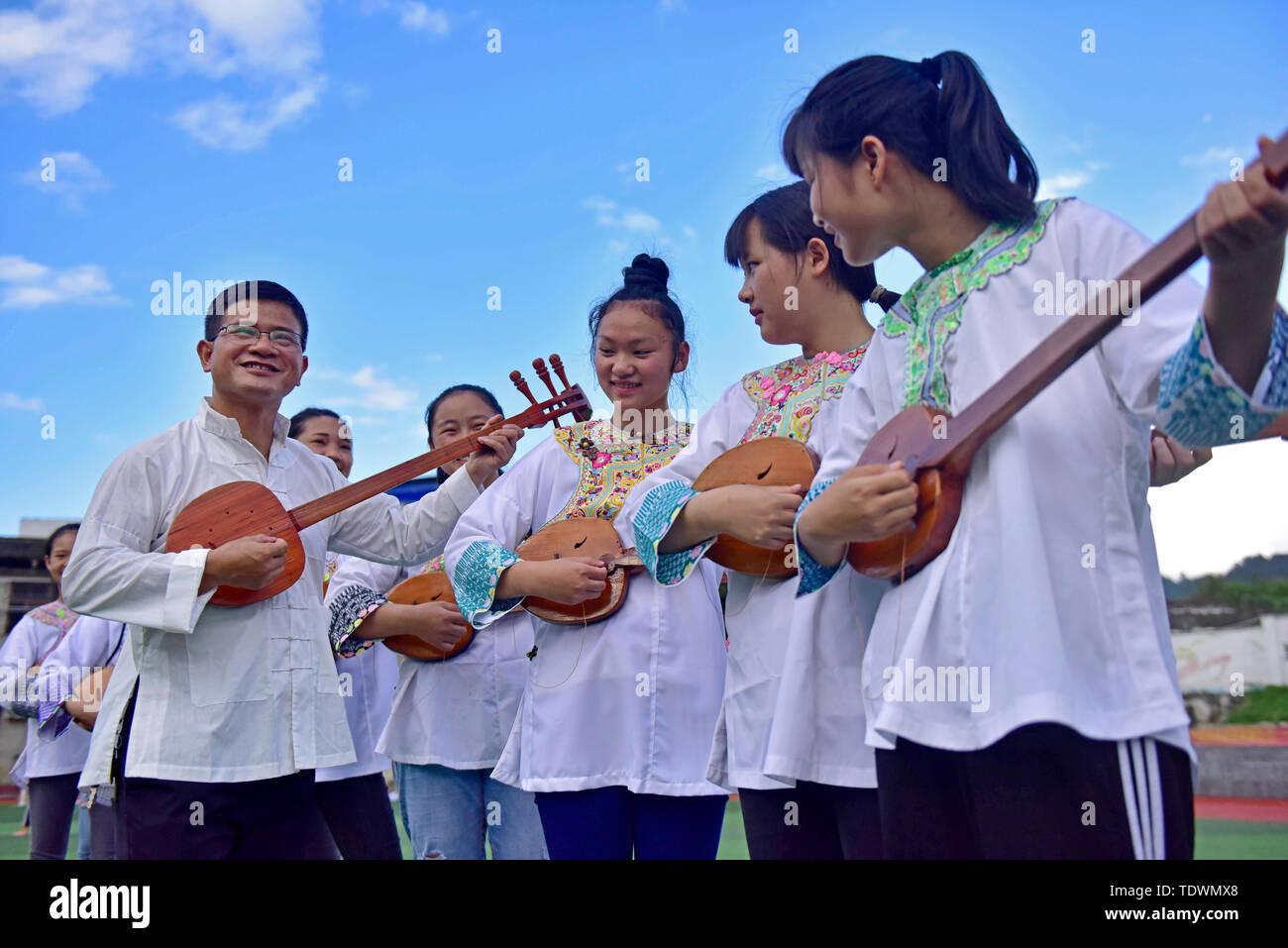 Qiandongnan, della Cina di Guizhou. 19 giugno 2019. Un insegnante guida gli studenti a pipa (4 corde liuto cinese) cantando la Dong gruppo etnico a Leli Middle School di Rongjiang contea di Qiandongnan Miao e Dong prefettura autonoma, a sud-ovest della Cina di Guizhou, 19 giugno 2019. Nel corso degli anni, varie attività dei gruppi etnici sono stati lanciati in Rongjiang County, in modo che gli studenti possano imparare in un ambiente con colture diversificate e di ereditare le culture etniche. Credito: Jiang Zuoxian/Xinhua/Alamy Live News Foto Stock