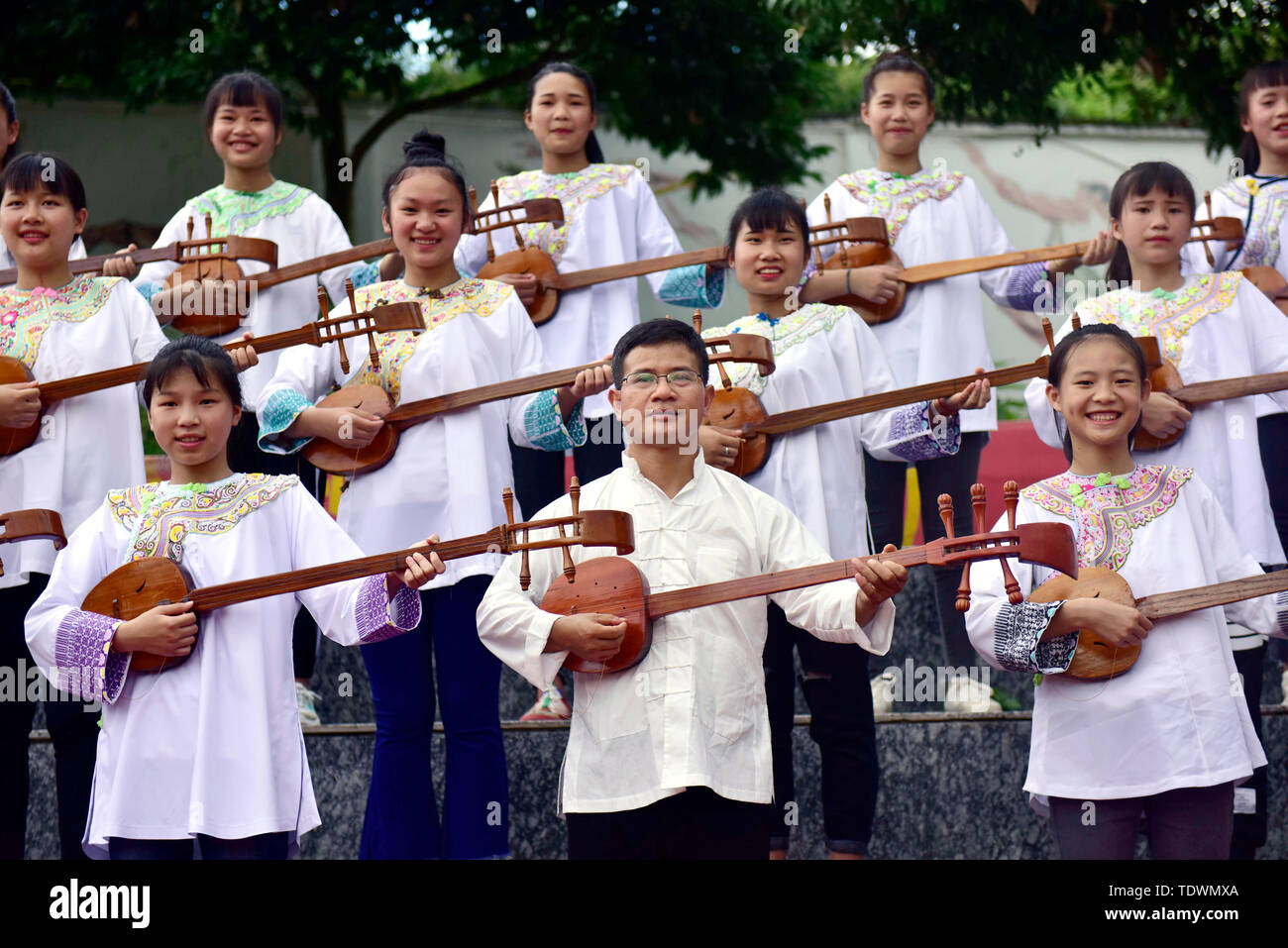 Qiandongnan, della Cina di Guizhou. 19 giugno 2019. Un insegnante (C) e gli studenti svolgono pipa (4 corde liuto cinese) cantando la Dong gruppo etnico a Leli Middle School di Rongjiang contea di Qiandongnan Miao e Dong prefettura autonoma, a sud-ovest della Cina di Guizhou, 19 giugno 2019. Nel corso degli anni, varie attività dei gruppi etnici sono stati lanciati in Rongjiang County, in modo che gli studenti possano imparare in un ambiente con colture diversificate e di ereditare le culture etniche. Credito: Jiang Zuoxian/Xinhua/Alamy Live News Foto Stock