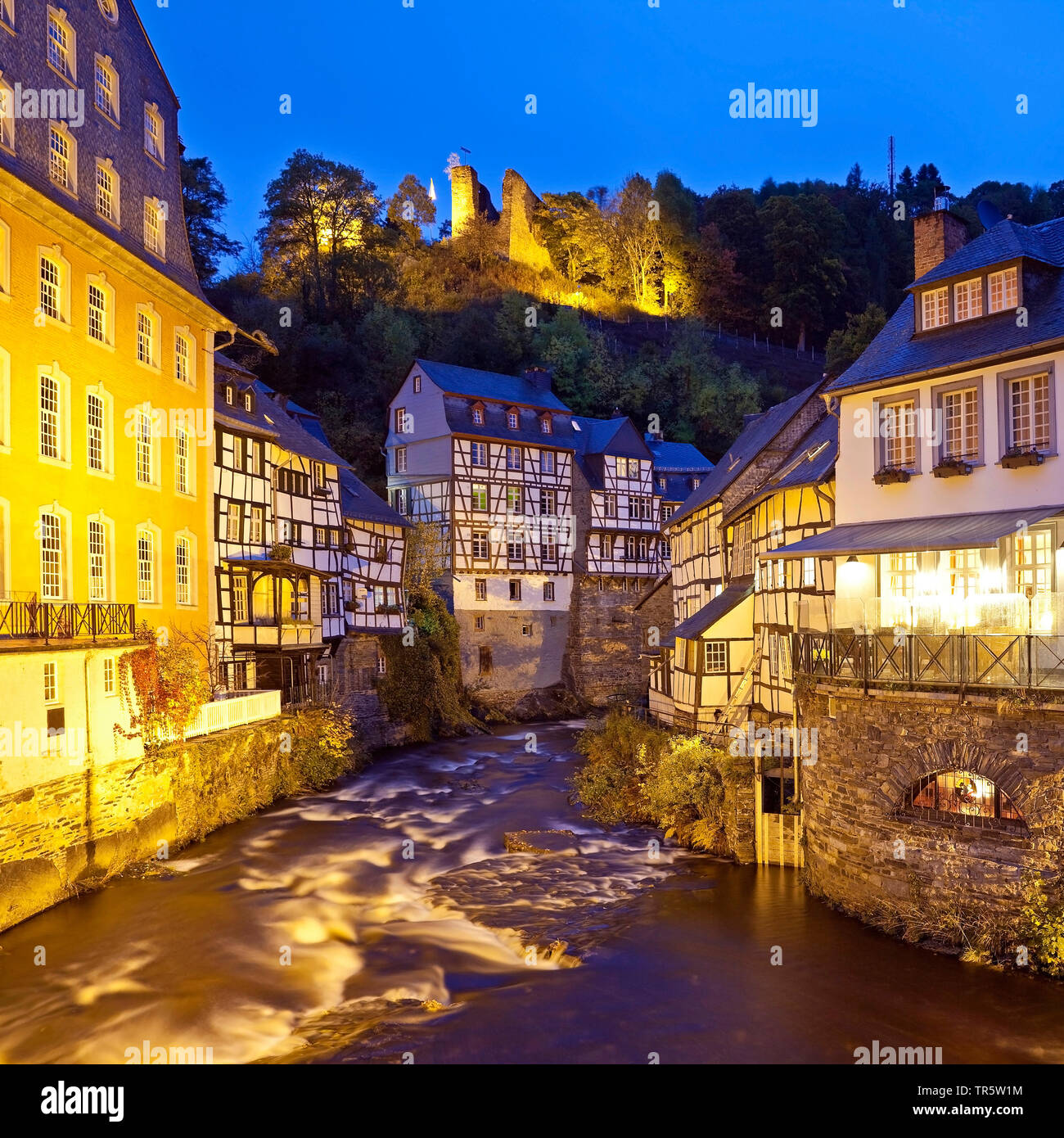 In legno case in fiume Rur in Monschau nella luce della sera, in Germania, in Renania settentrionale-Vestfalia, Monschau Foto Stock