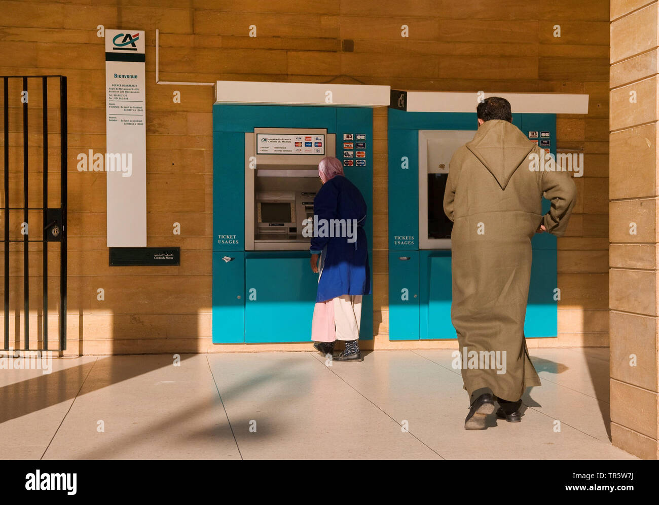 Donna con velo e uomo ad un cash dispenser automatici, Marocco, Quarzazate Foto Stock