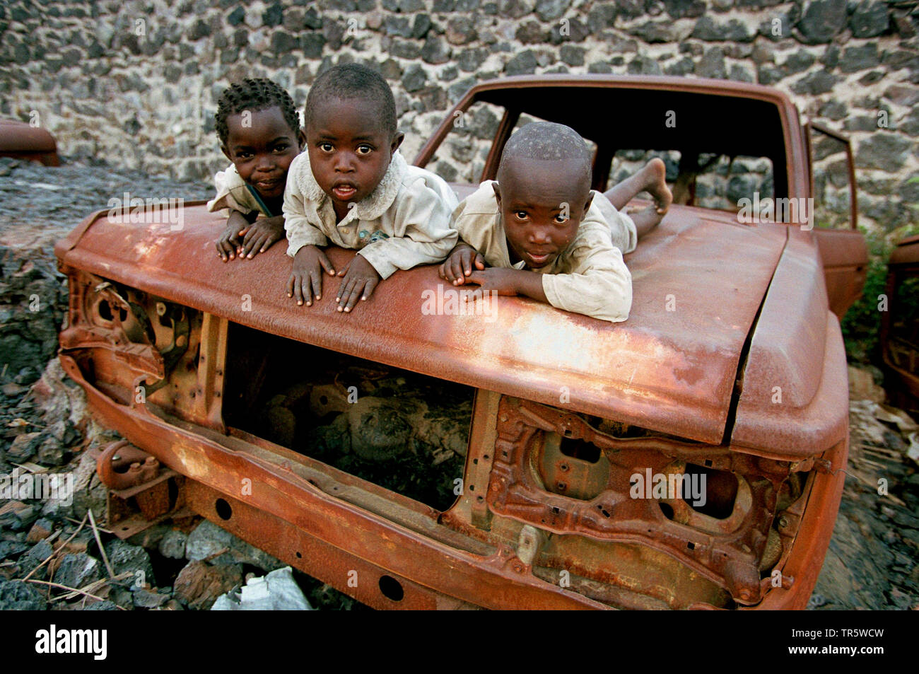 Bambini che giocano su auto rottamate, Repubblica Democratica del Congo, Goma Foto Stock