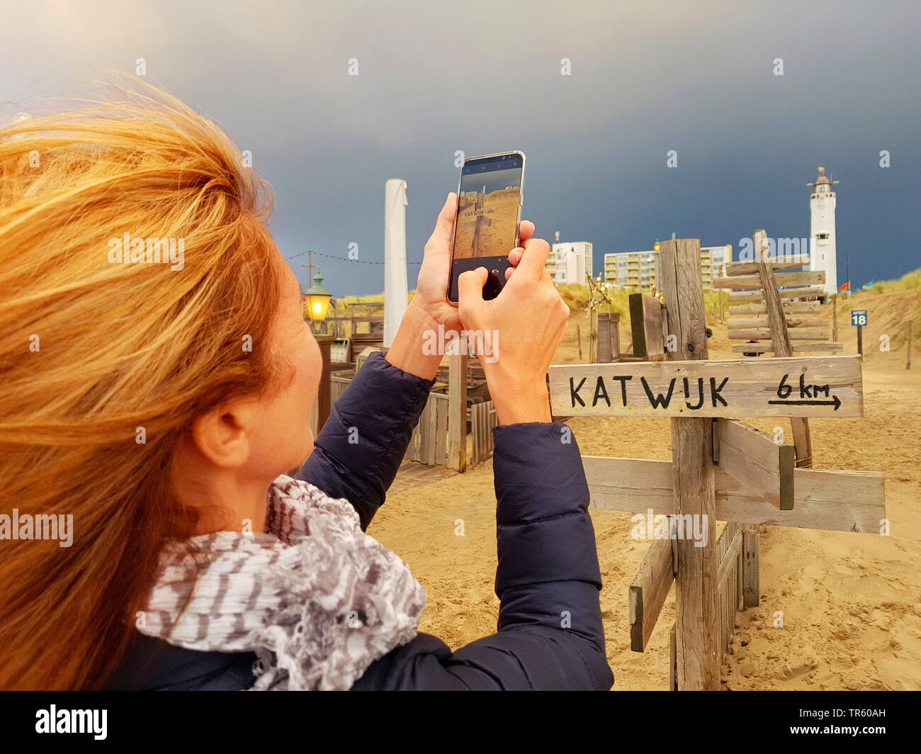 Donna prendendo la foto del faro di Noordwijk, cartelli segnaletici di Katwijk, Paesi Bassi, Noordwijk aan Zee Foto Stock
