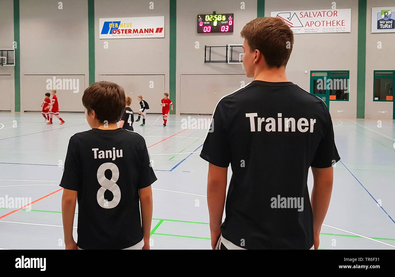 Ragazzo e coacher in una sala sportiva al gioco socker, Germania Foto Stock