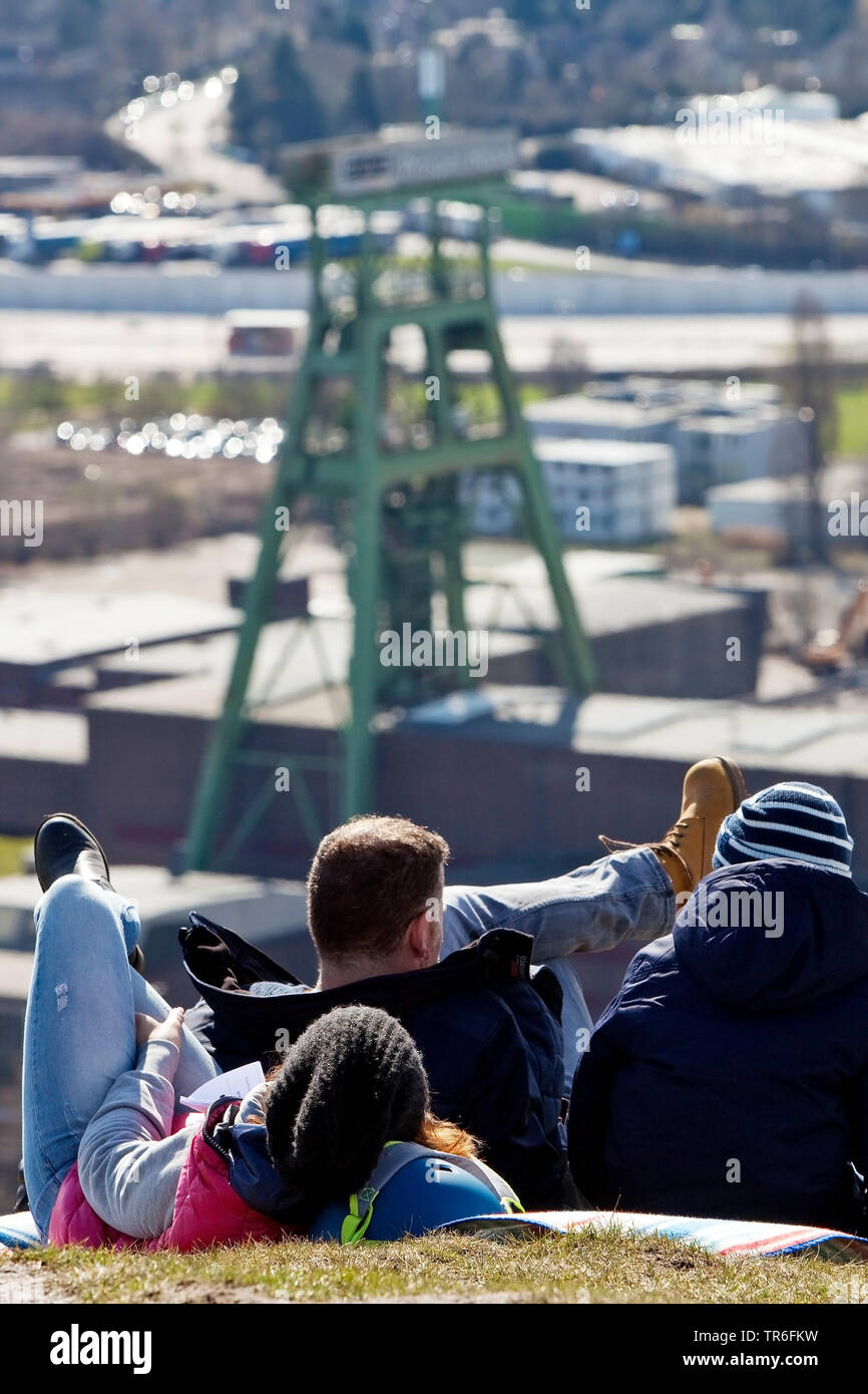 Persone che giace sul bottino pit Haniel e guardando il telaio della testa del buon Haniel, in Germania, in Renania settentrionale-Vestfalia, la zona della Ruhr, Bottrop Foto Stock