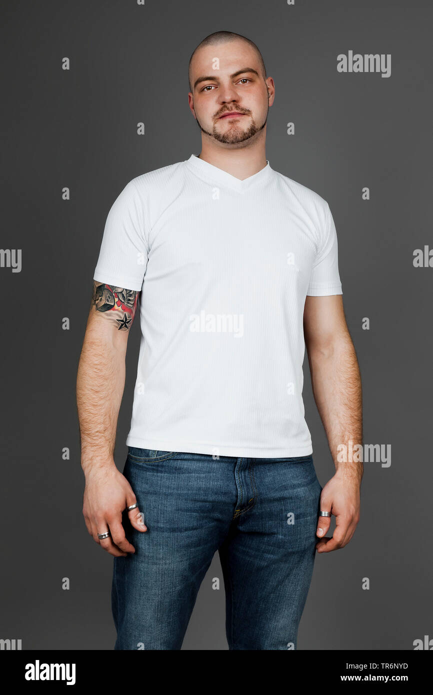 Giovani tatuati uomo in maglietta e jeans, Germania Foto Stock