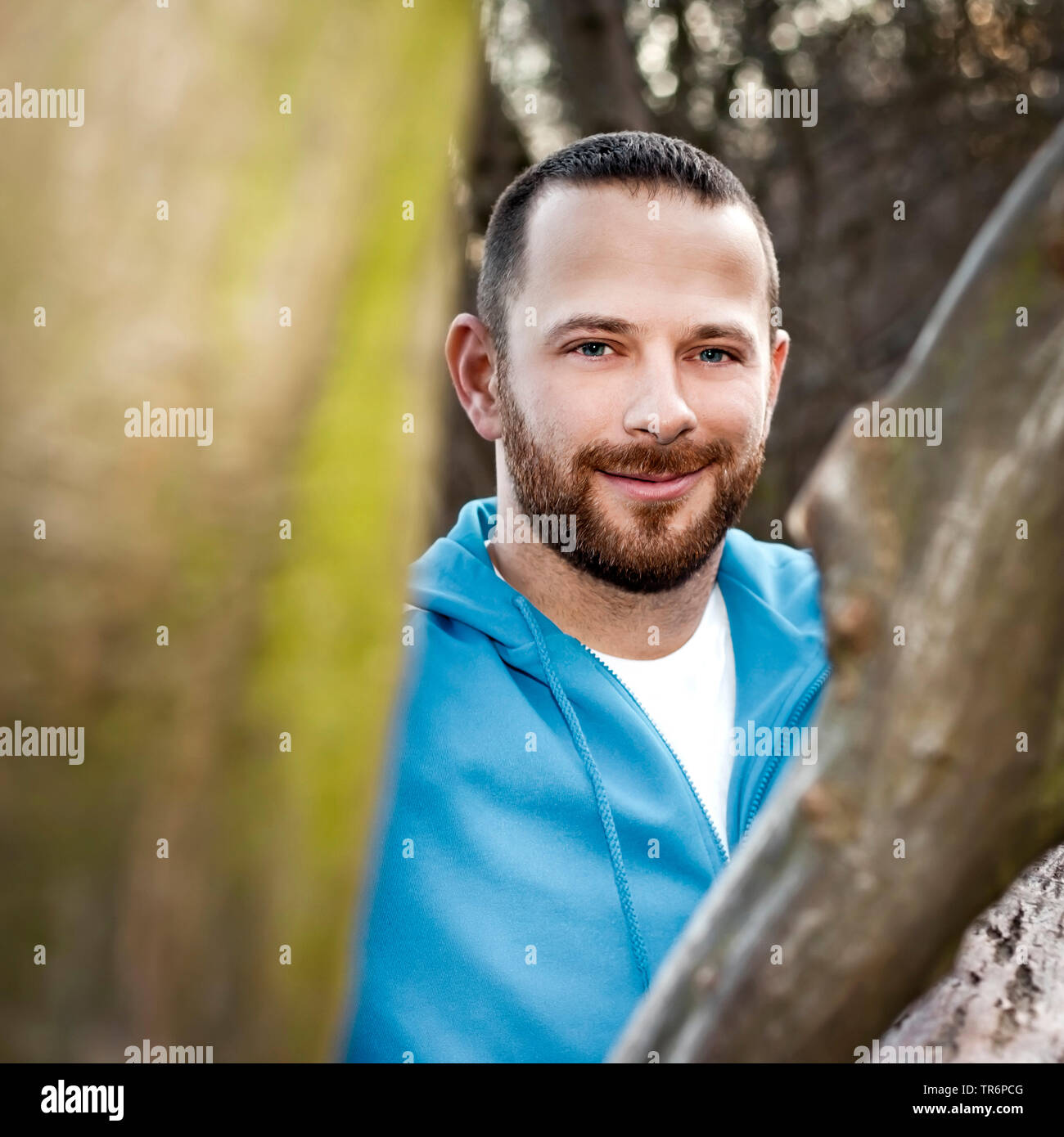 Uomo bello in natura ad un tronco di albero, Germania Foto Stock