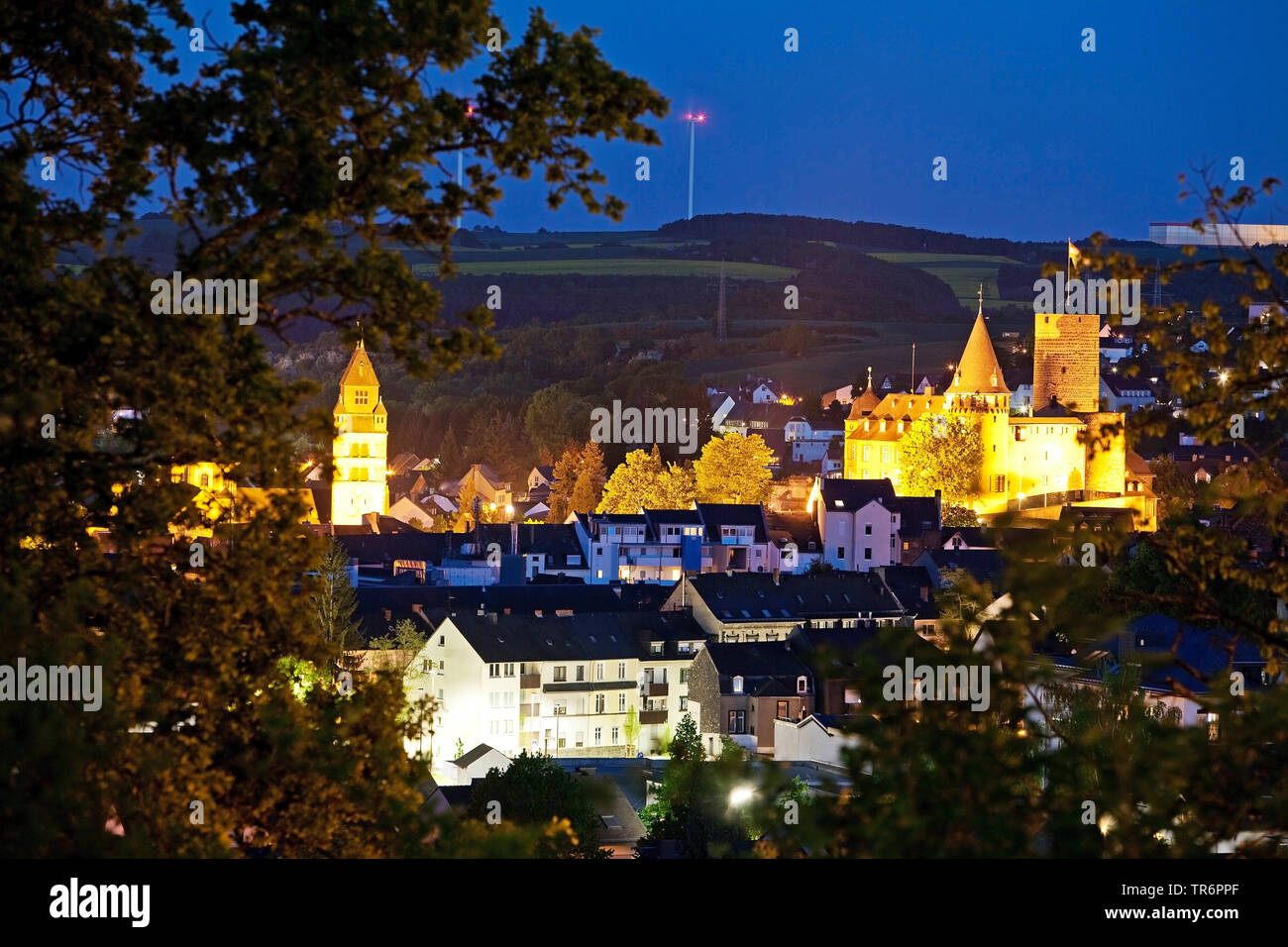 Vista della città con Genovevaburg illuminata di sera, in Germania, in Renania Palatinato, Eifel, Mayen Foto Stock
