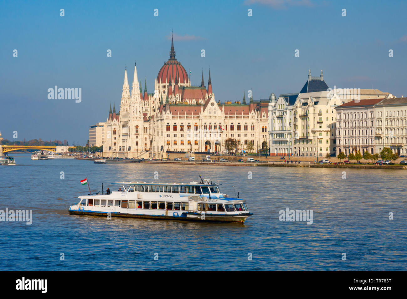 La barca turistica sul Danubio con il parlamento ungherese edificio (Orszaghaz) in background sotto un cielo blu. Budapest, Ungheria. Foto Stock