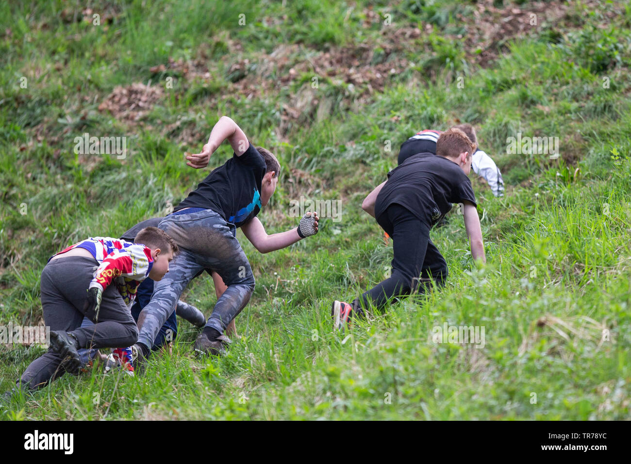 I bambini la gara in salita durante l annuale Spring bank holiday formaggio-evento di rotolamento alla Cooper's Hill vicino a Gloucester, maggio 2019. Foto Stock