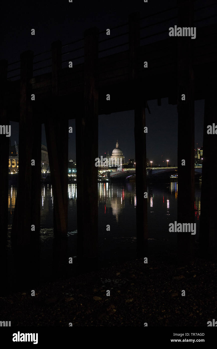 La Cattedrale di St Paul e all'alba, fotografata dalle sponde del fiume Tamigi sotto un vecchio stile vittoriano molo in legno, London, England, Regno Unito Foto Stock