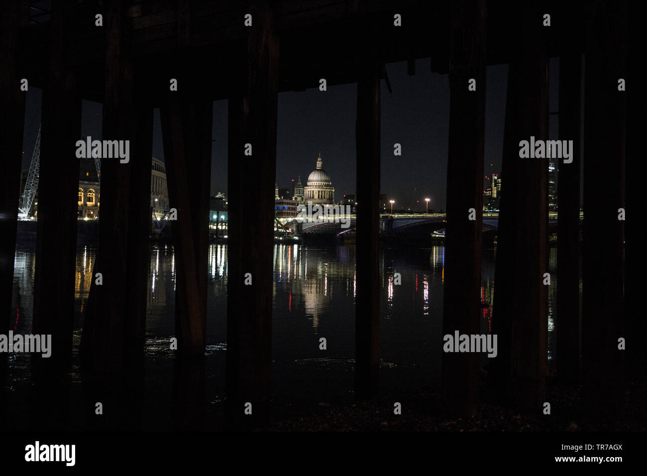 La Cattedrale di St Paul e all'alba, fotografata dalle sponde del fiume Tamigi sotto un vecchio stile vittoriano molo in legno, London, England, Regno Unito Foto Stock