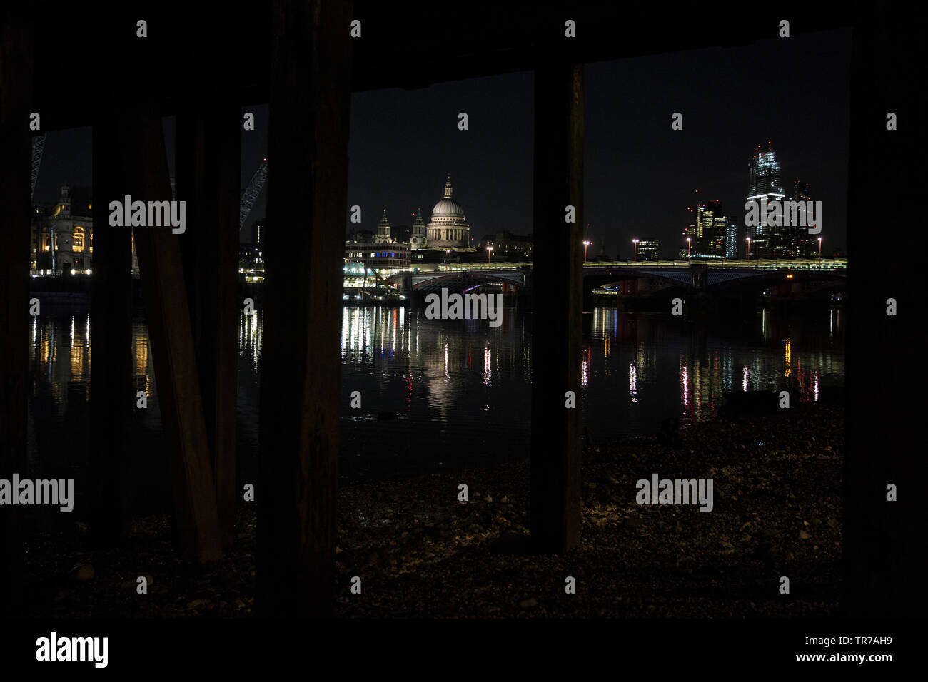 La Cattedrale di St Paul e all'alba, fotografata dalle sponde del fiume Tamigi sotto un vecchio stile vittoriano molo in legno, London, England, Regno Unito Foto Stock