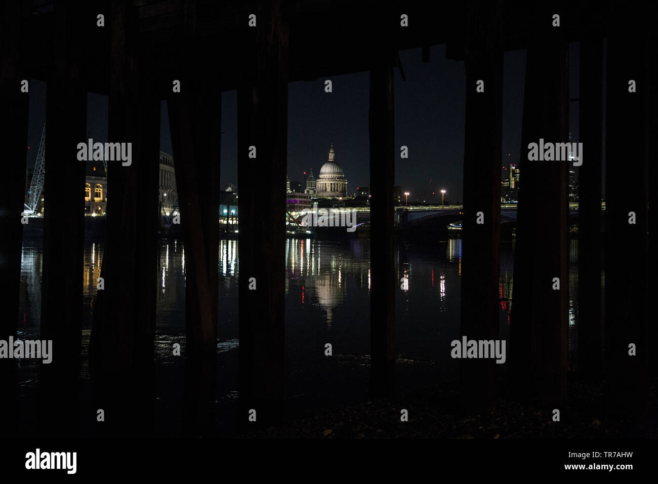 La Cattedrale di St Paul e all'alba, fotografata dalle sponde del fiume Tamigi sotto un vecchio stile vittoriano molo in legno, London, England, Regno Unito Foto Stock