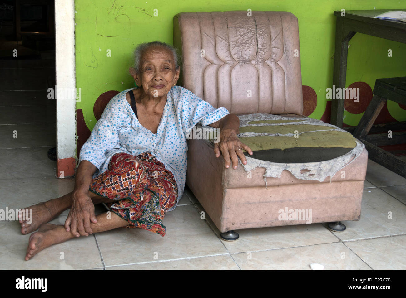 Titolare di pensione o di rendita fragile a guardare i turisti al rainbow villaggio di Kampung Pelangi sull isola indonesiana di Giava Foto Stock