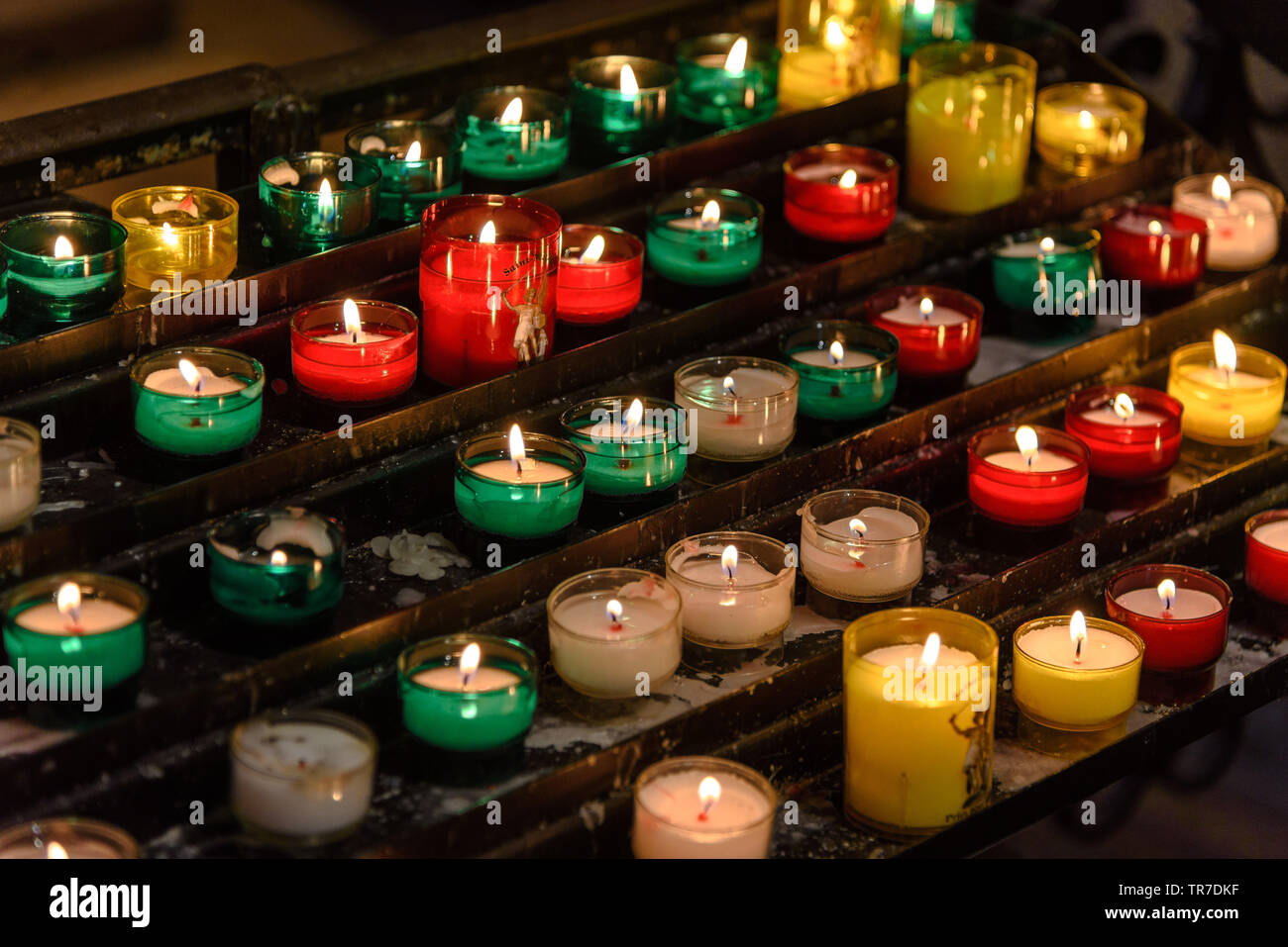 Lit / votive candele di preghiera all interno della Basilica di San Pietro a Mont Saint-Michel Foto Stock