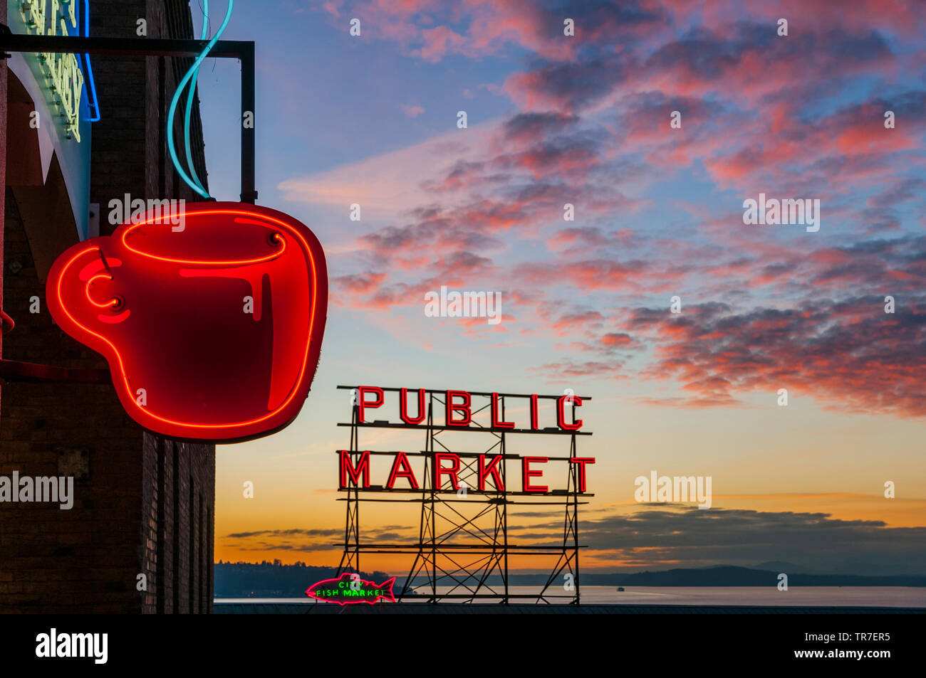 Tazza di caffè insegna al neon con il Pike Market insegna al neon in background al tramonto, Seattle, Washington, Stati Uniti d'America Foto Stock