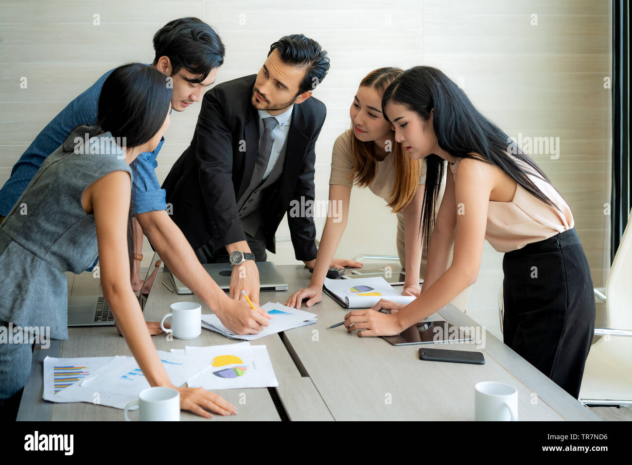 Smart manager spiegando riunione interna al suo team di progetto in un ufficio moderno. La multi etnico persona business group in tuta. Progetto e Business c Foto Stock