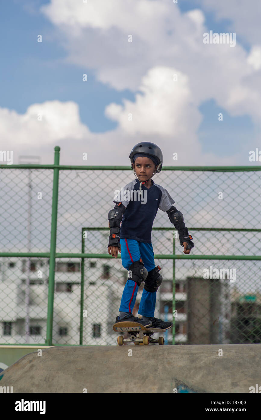 Un ragazzo indiano preparando andare giù per una rampa da skateboard Foto Stock