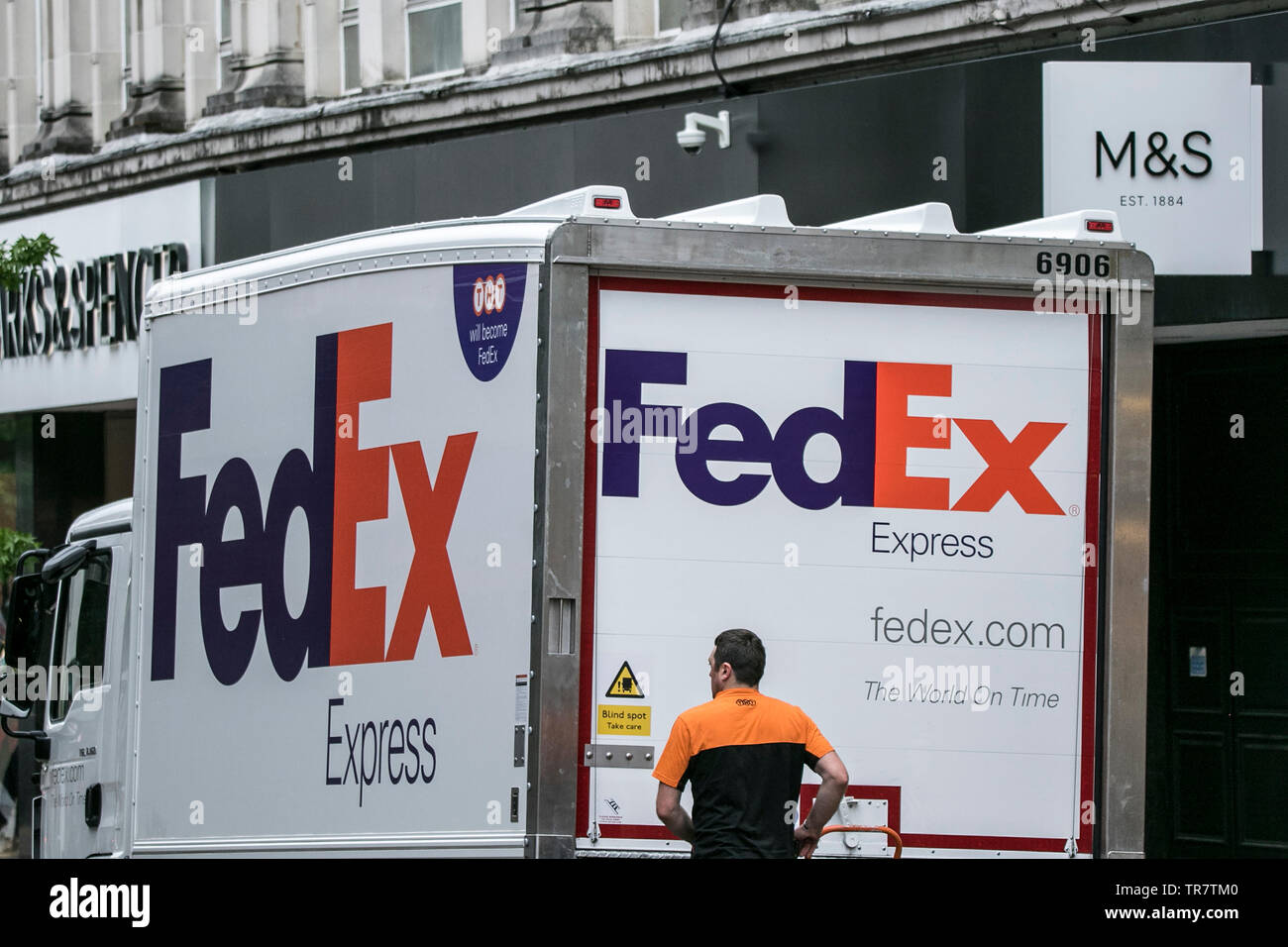 Un FedEx van driver e consegnare i pacchi di Marks & Spencer in Preston, Lancashire Regno Unito Foto Stock