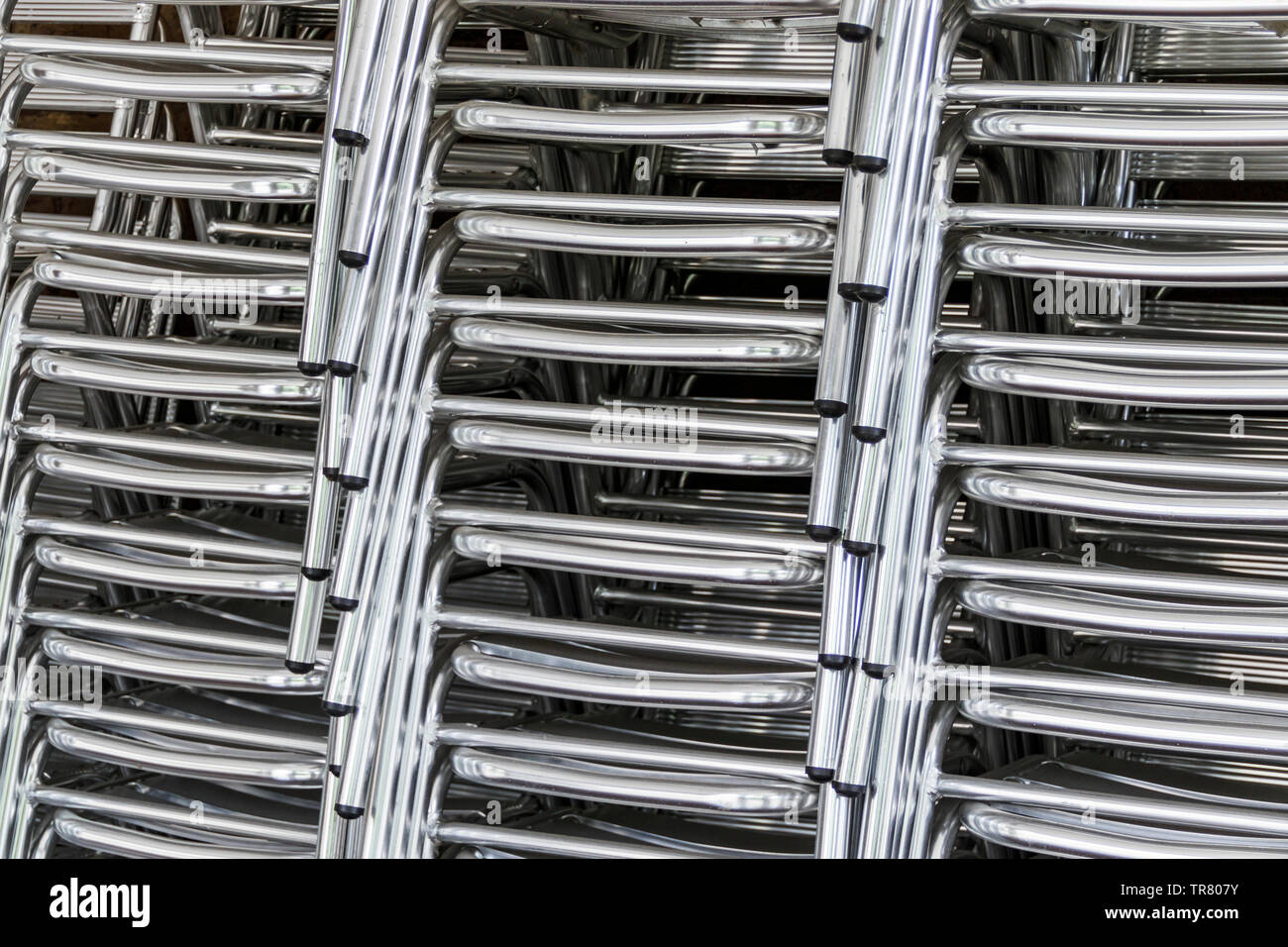 Close-up di tre pile di alluminio lucido sedie tubolare Foto Stock
