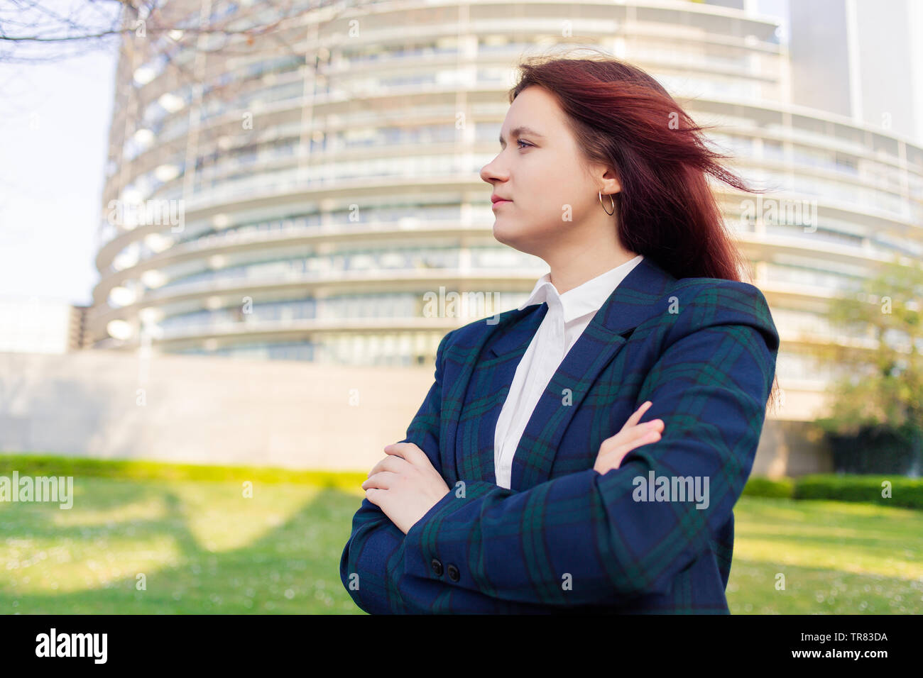 Certi imprenditori donna giovane imprenditrice ritratto contro ufficio edificio dello sfondo. Imprenditrice caucasica. Happy business donna po Foto Stock