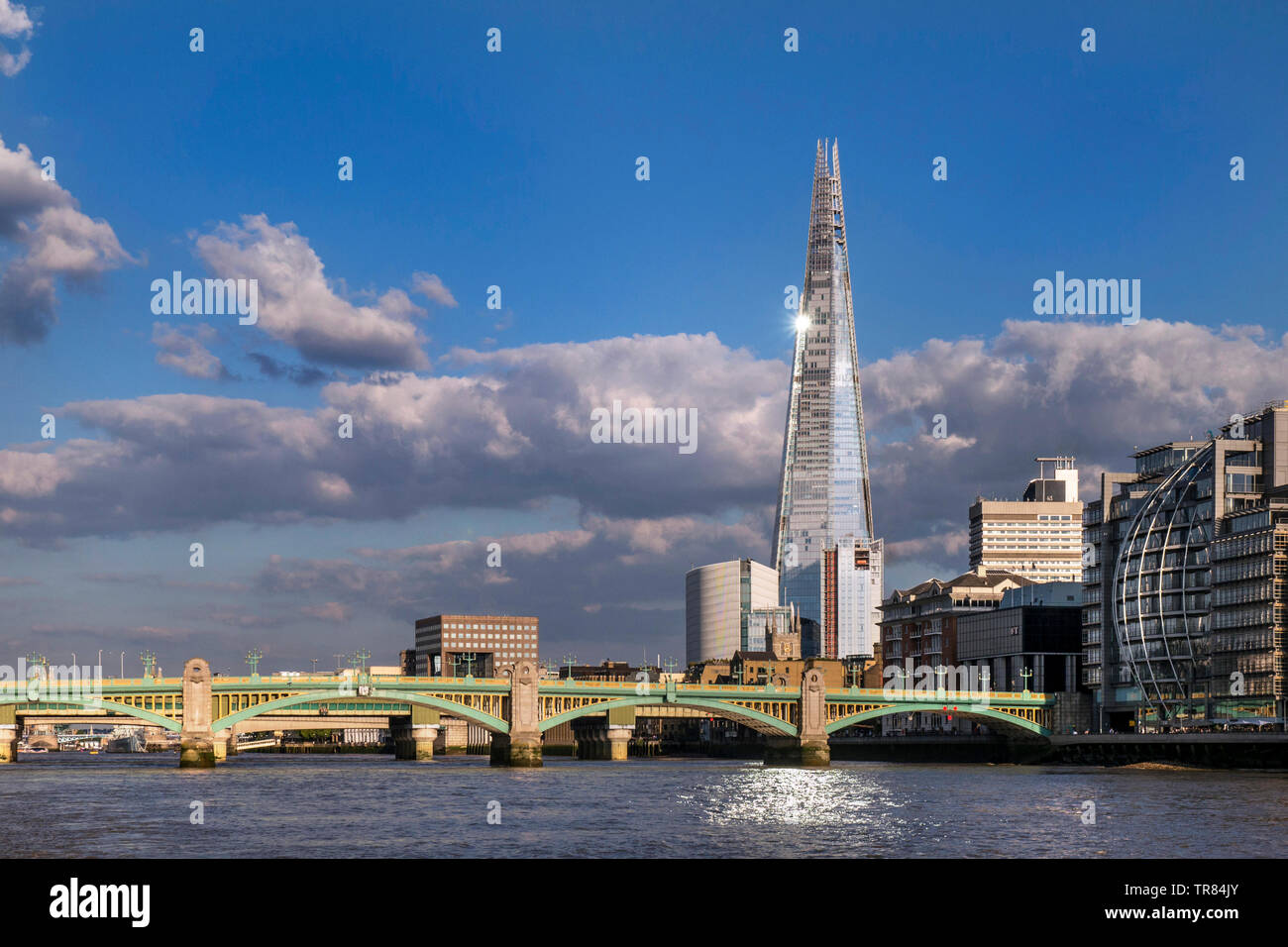 Il London Shard con sunburst e la riflessione della luce nel fiume Tamigi, South Bank con Southwark Bridge e il London Bridge dietro Southwark London REGNO UNITO Foto Stock