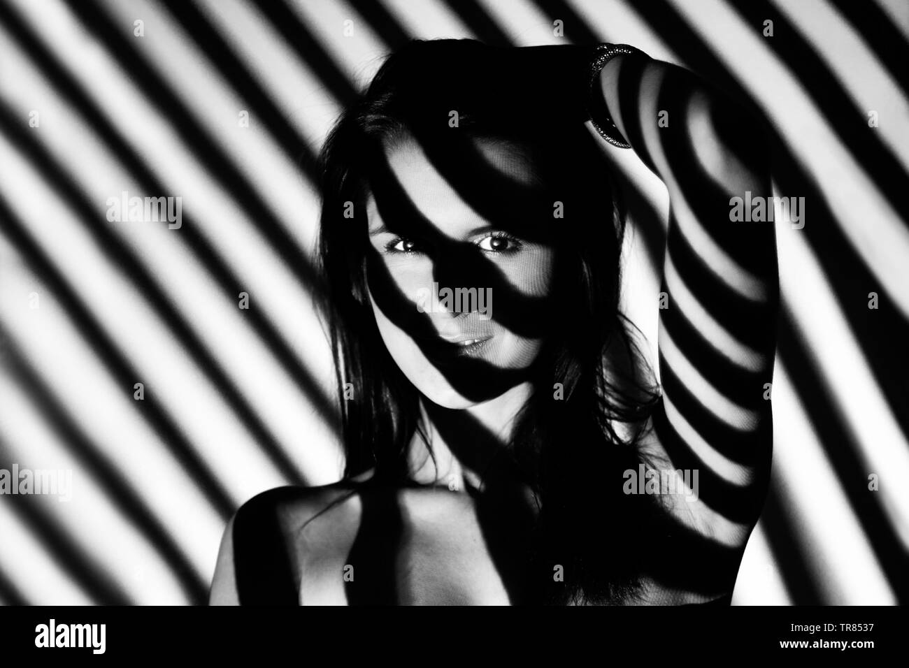 Giovane donna con ombre di contrasto Foto Stock