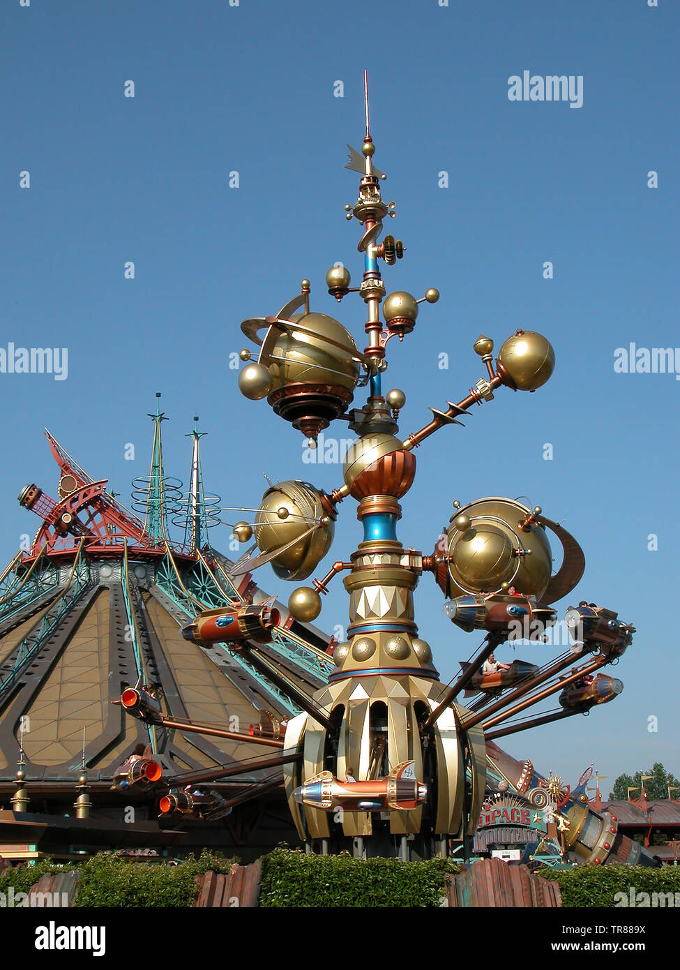 Il Orbitron, Macchine Volantes : un razzo spinner attrazione in Discoveryland, Disneyland Park, Parigi, con uno spazio di montagna dietro Foto Stock