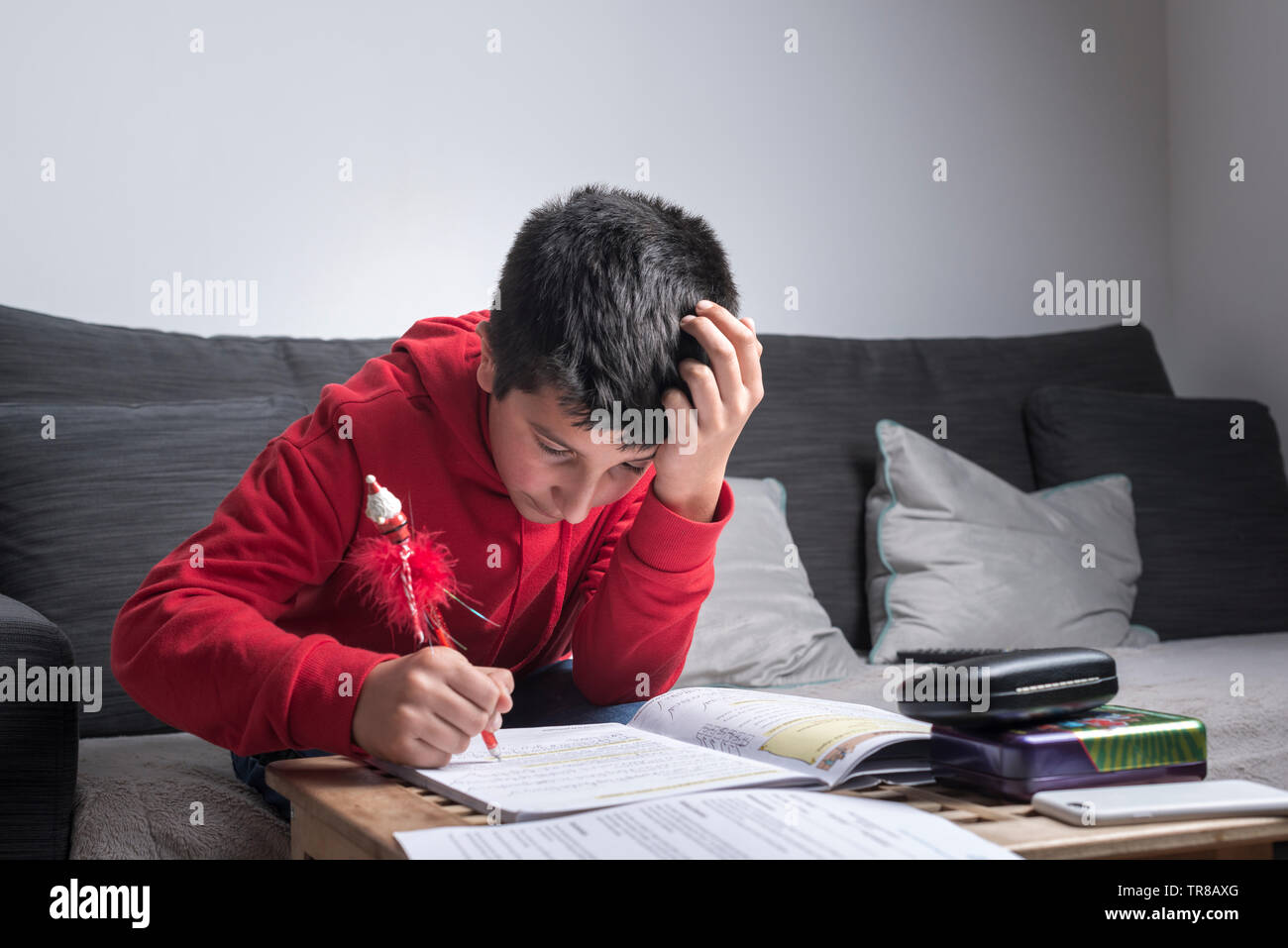 Regno Unito, schoolboy(11-12) lavorando sui suoi compiti Foto Stock