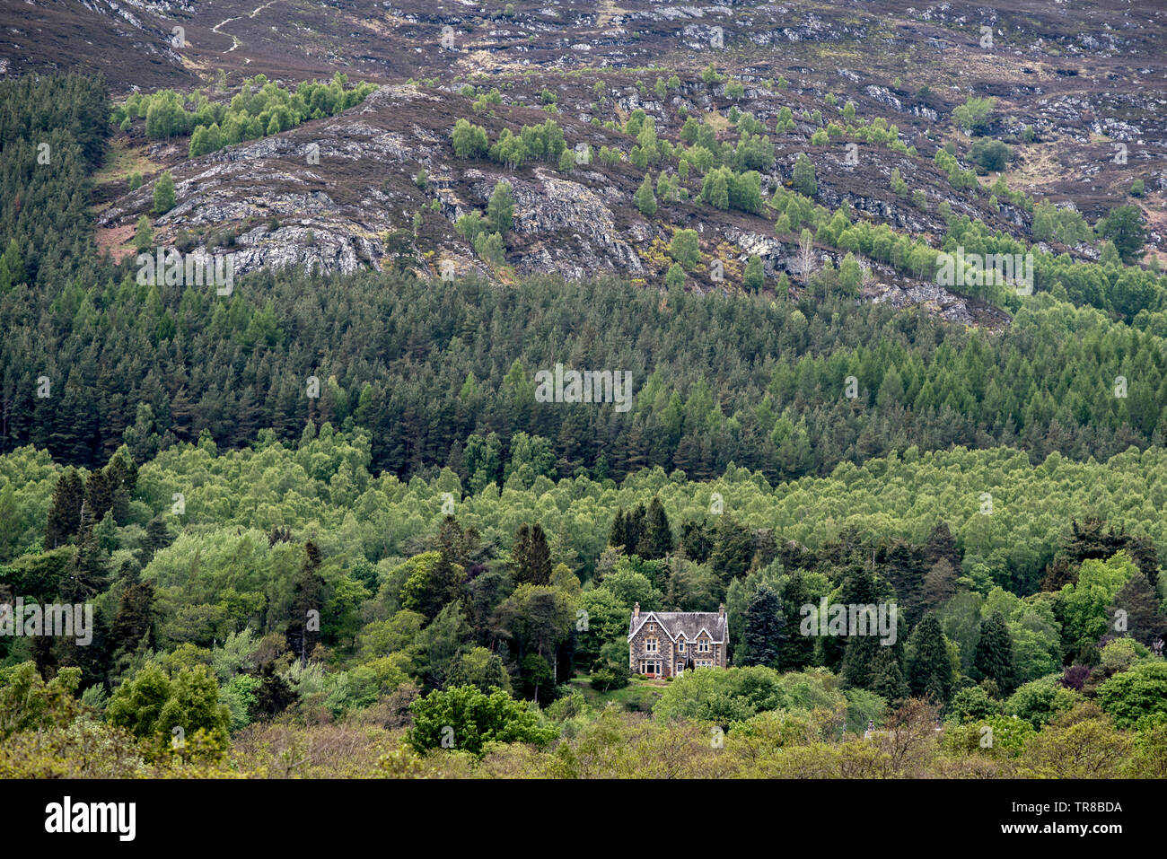 La vista dalla caserma Ruthven verso una casa solitario ai piedi di Creag Bheag vicino a Kingussie in Cairngorm National Park, Scotland, Regno Unito. Foto Stock