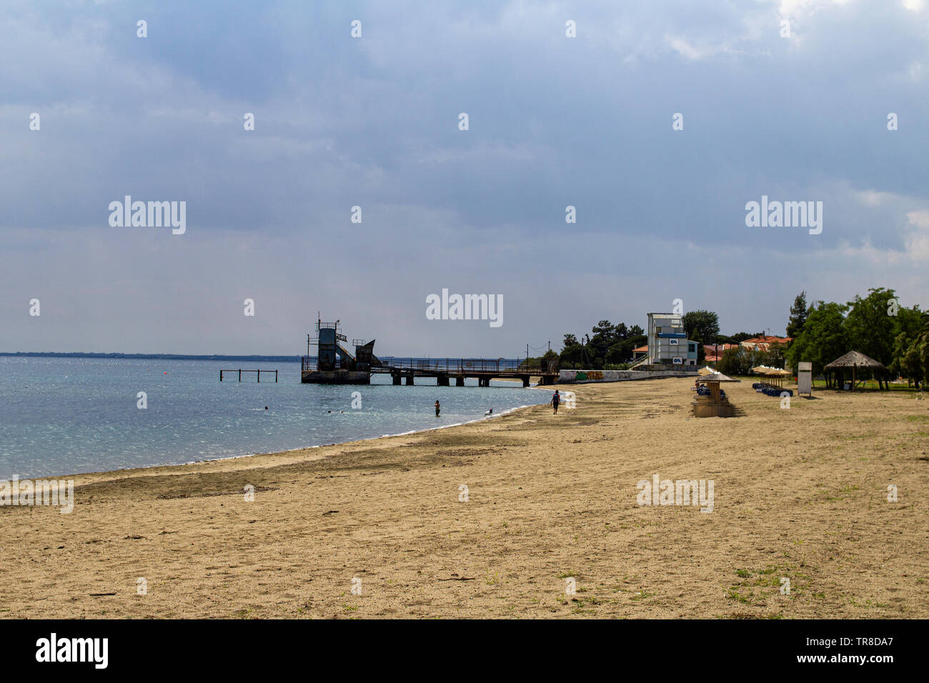 La spiaggia e il piccolo molo presso la piccola località turistica e balneare di Gerakini.Halkidiki, Grecia. Foto Stock