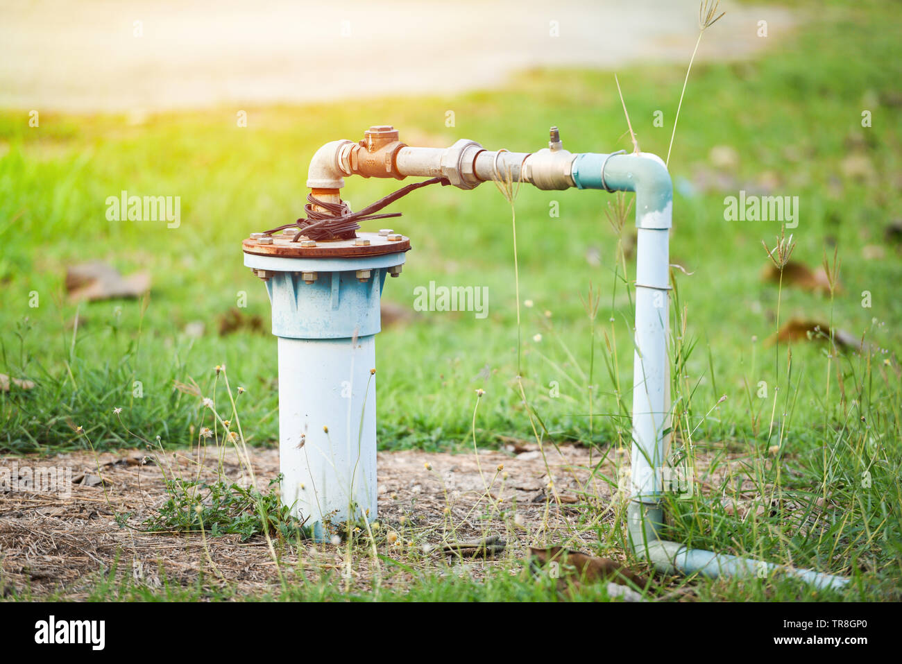Acque sotterranee bene con il tubo in PVC e il sistema elettrico di profondo bene pompa sommergibile acqua sul prato verde Foto Stock