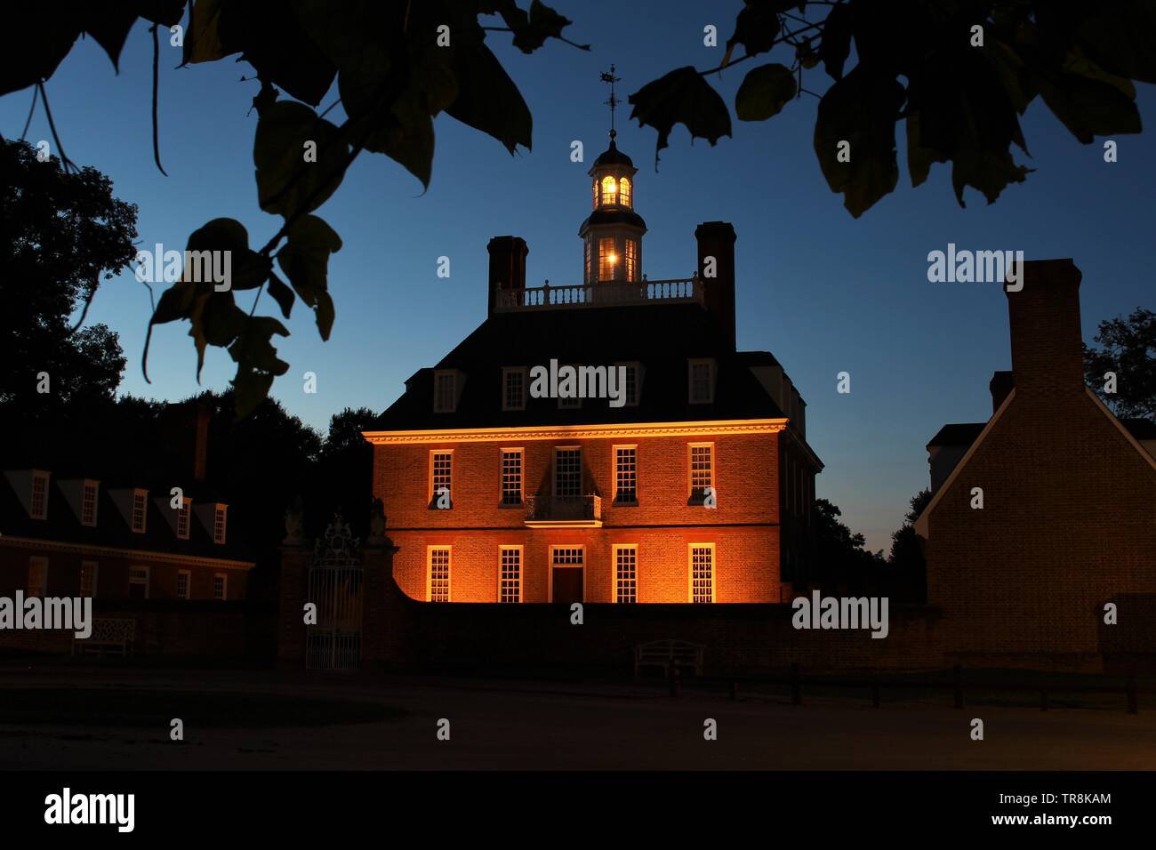 Williamsburg Coloniale Palazzo del Governatore vista dal cancello anteriore, per la stagione estiva di notte con alberi in primo piano Foto Stock