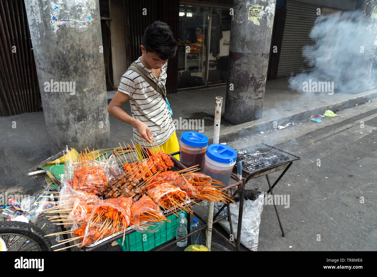 Manila, Filippine - Luglio 16, 2016: cibo di strada ragazzo del fornitore Foto Stock