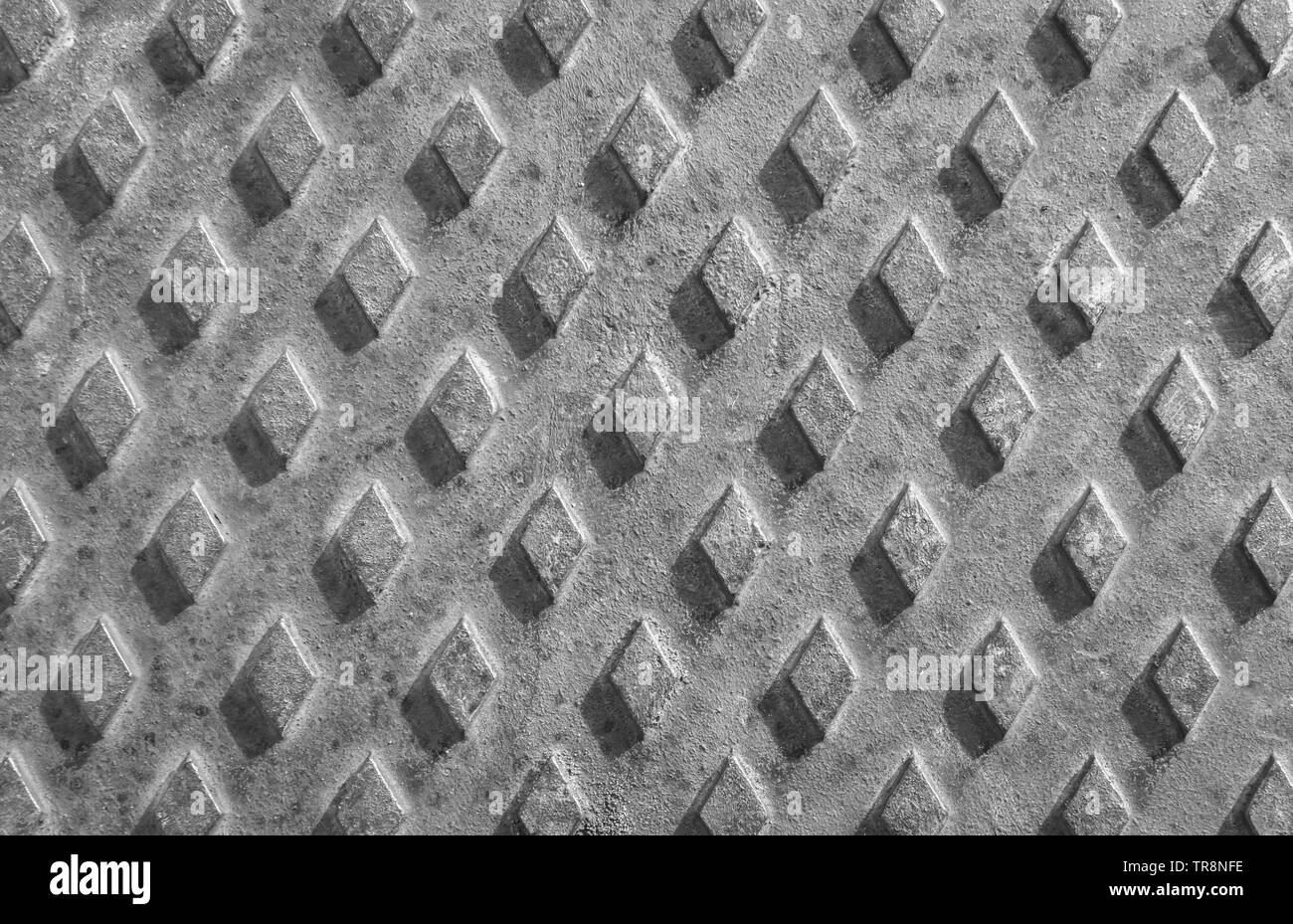 Vecchio arrugginito coperchio di scarico con uno sfondo con pattern di diamante. Foto Stock