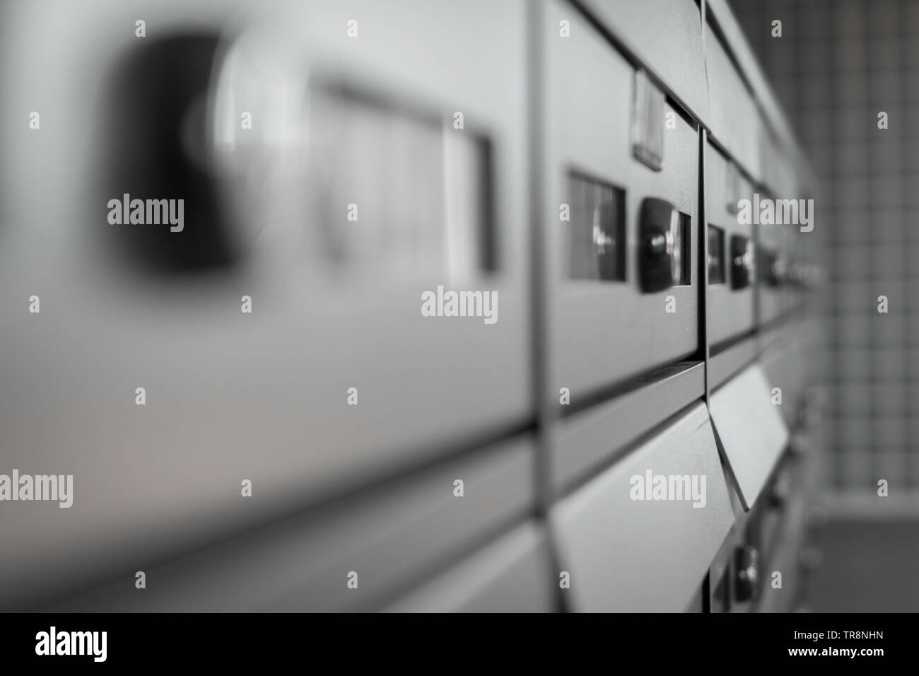 Extreme closeup dei moderni mailbox metallico in un condominio. Sfocati sfondo sfocato. Foto Stock