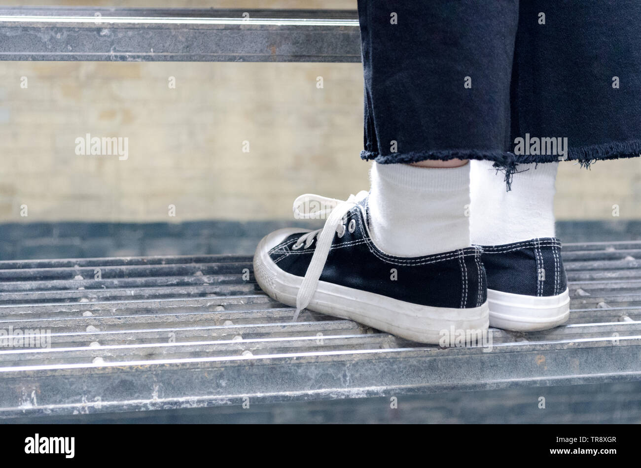 Vicino la vista posteriore dell'uomo salendo le scale in scarpe Foto Stock