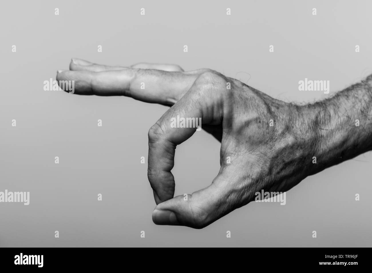 In prossimità di una mano mans rendendo un simbolo OK, in bianco e nero. Foto Stock