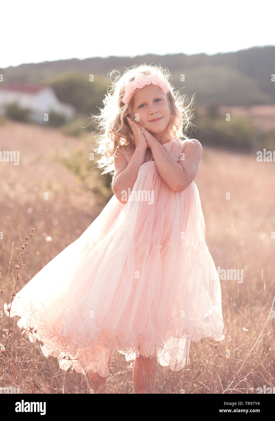 Sorridente bambina 5-6 anno indossando elegante abito rosa e floreale  cerchietto per capelli in prato. Guardando alla fotocamera. Durante la  stagione estiva. Infanzia Foto stock - Alamy
