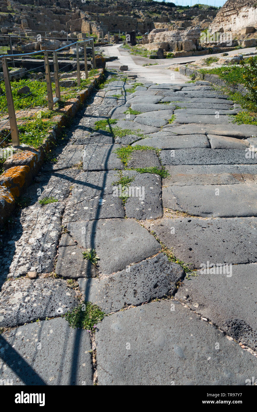 Un tratto di strada romana o pavimentazione a Tharros (Tharreas) nei pressi di Cabras nella Sardegna Occidentale, Italia Foto Stock