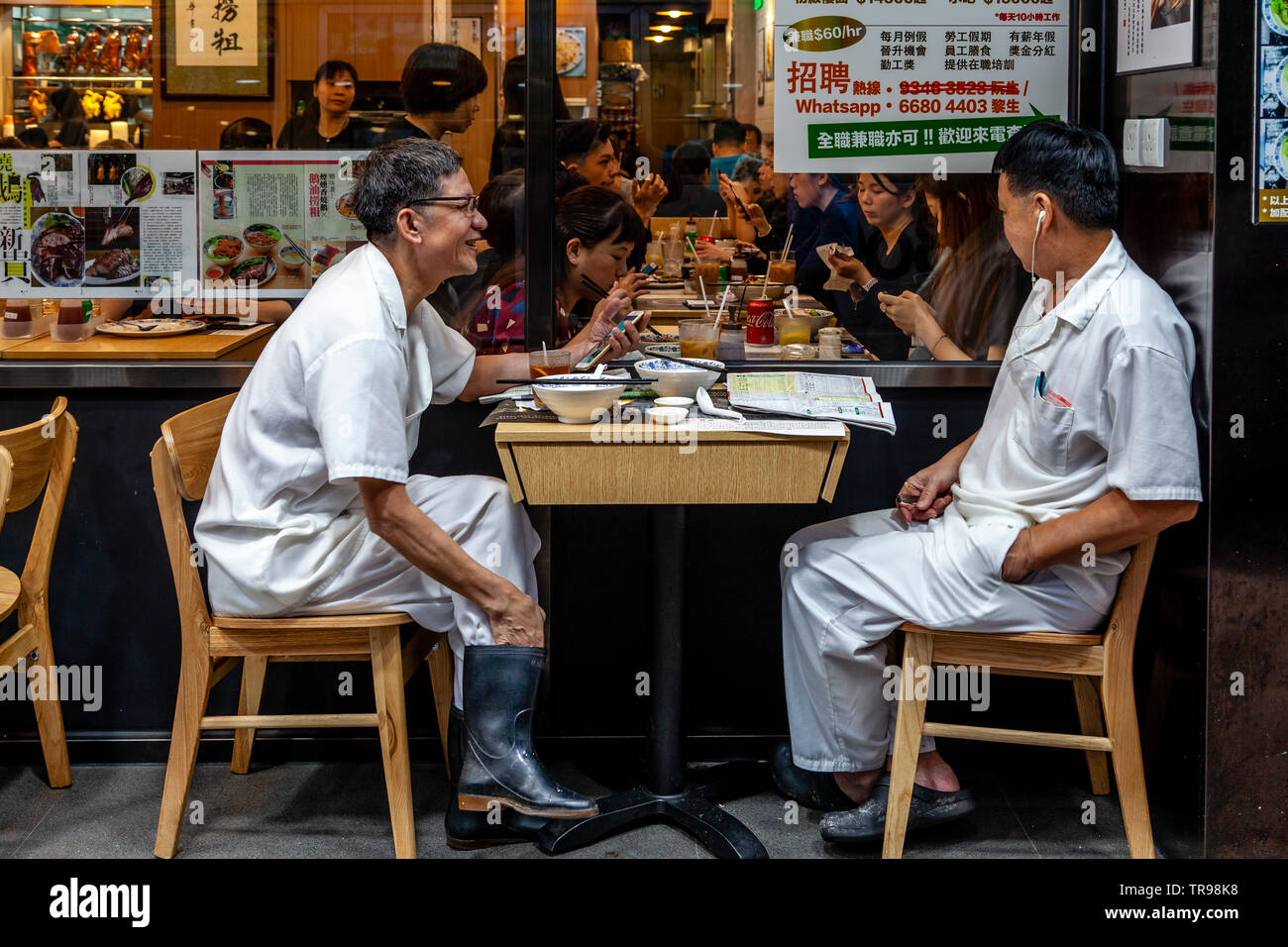 Due Hong Kong lavoratori godendo il pranzo, Hong Kong, Cina Foto Stock