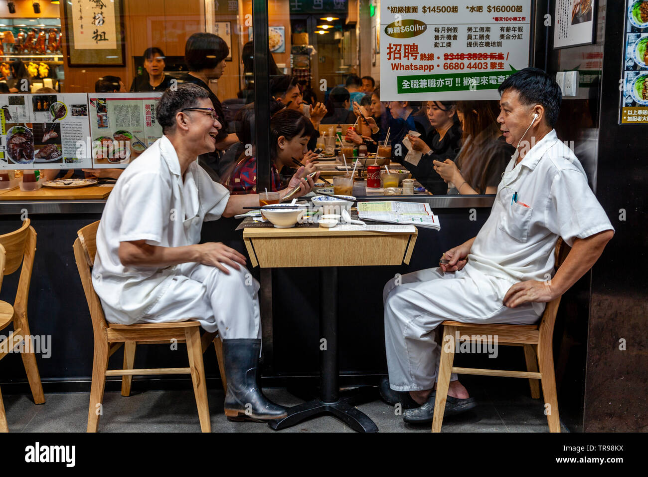 Due Hong Kong lavoratori godendo il pranzo, Hong Kong, Cina Foto Stock